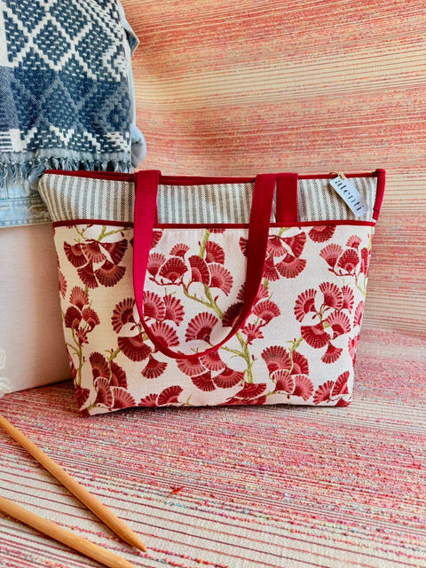 Atenti Charm Satchel with red ginkgo leaf motifs with striped trim and long handles.