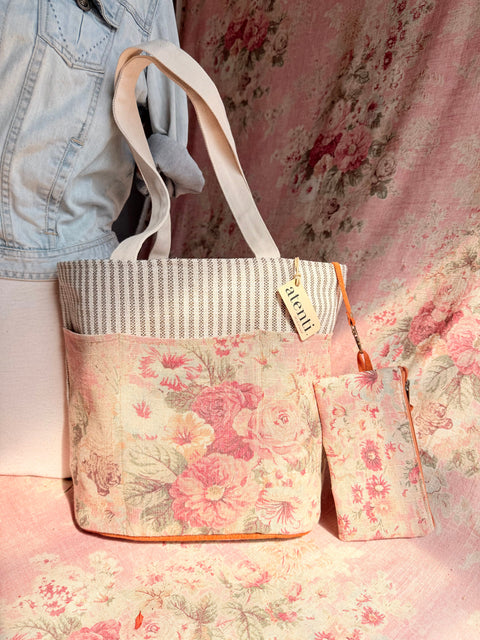 Atenti Rosewood Project Tote with pink roses on a pale background, striped top trim, light handles and matching zipper pouch.