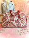 Patterned fabric overnight handbag with red and beige design on a floral background