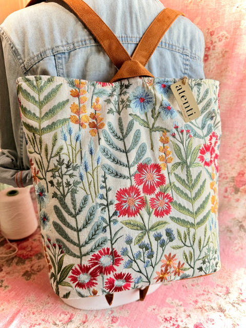 Atenti Wildflower Backsac with colorful embroidered flowers on cream fabric.