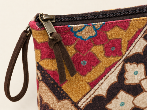 Close-up of the zipper, brown wrist loop and colorful floral cotton fabric on Atenti Fables Grand Pouch.