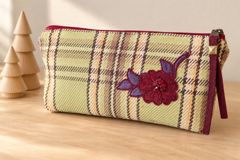 Atenti Mistletoe Plaid Tall Tool Pouch beside wooden Christmas trees, showing sage plaid and burgundy floral applique.
