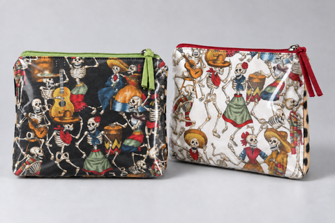 Black and white Dia de Muertos skeleton zipper pouches shown together